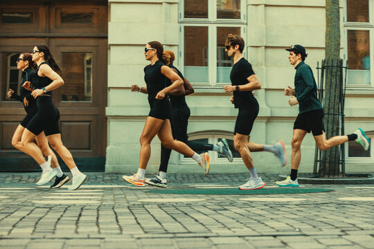 Running group training together on a city street for urban fitness and endurance