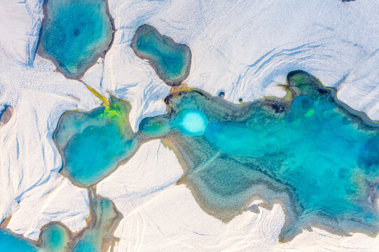 Aerial view of turquoise meltwater pool in Iceland glacial silt