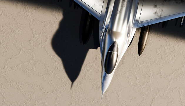 Top view of a military fighter aircraft flying over a desert
