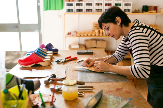 Shoemaker working on template in her workshop