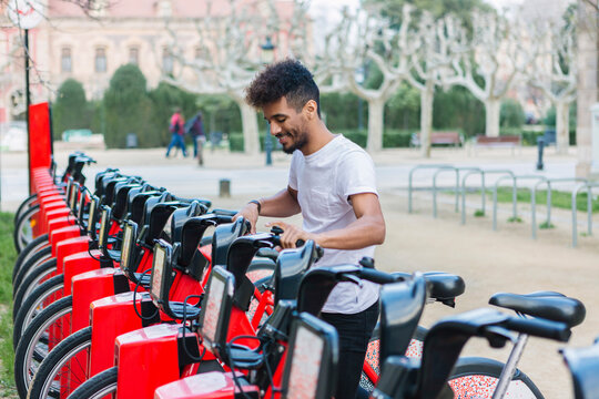 Young man taking a rental bike, Barcelona, Spain