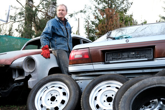 Hobby mechanic resting by classic car in garden
