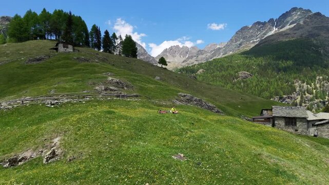 Dosso dei vetti, Chiesa in Valmalenco, Italy: Mountain Biker rests drone view from the top in the middle of the valley on a Sunny Day