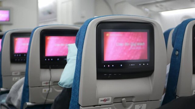 interior view to airplane seat with personal screen entertainment on every seat full with passenger ready for departure traveling, aircraft airplane cabin wide body seat full with passenger