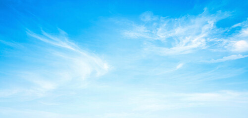 Beautiful blue sky background with soft white clouds, bright daylight and copy space for design banner concepts © Choat