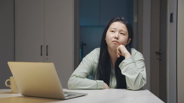 Creative and idea crisis, boring businesswoman having long day work from home on laptop computer looking away thinking with lack of motivation and concentration, female experiencing stress and burnout