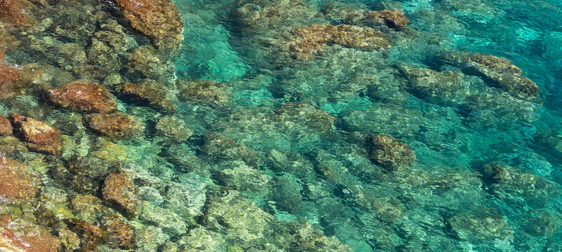 Transparent turquoise Mediterranean water with rocky seabed texture