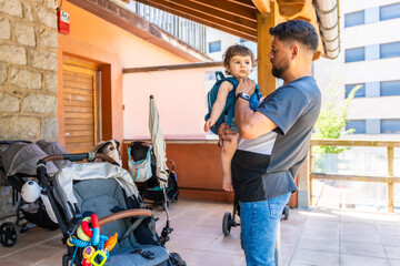 Father holding young son wearing backpack arriving from school © unai
