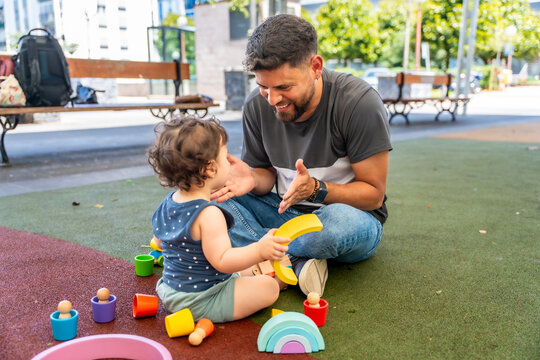 Father and son playing together with wooden toys
