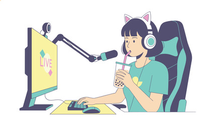 Fototapeta premium Young female gamer wearing cat ear headphones streams live video while drinking boba tea at her computer desk.