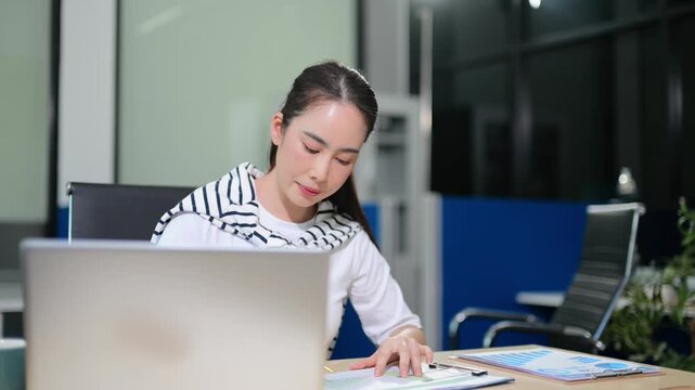 Focused female entrepreneur analyzing financial growth charts on a digital tablet at her office desk. Perfect for modern corporate, tech, and data analysis concepts.