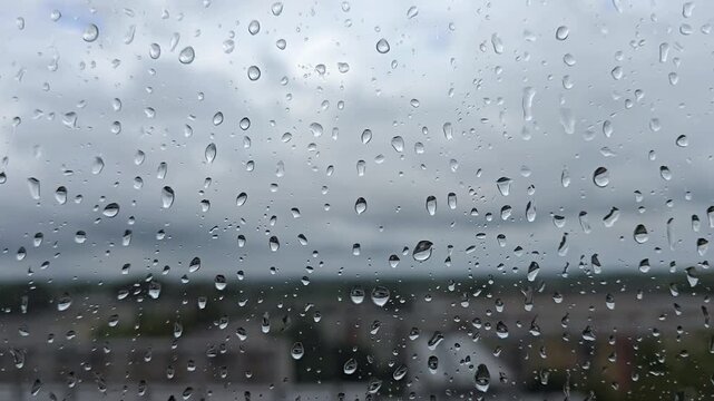 Drops of the rain sliding down slowly on window glass, rainstorm, rainy season,