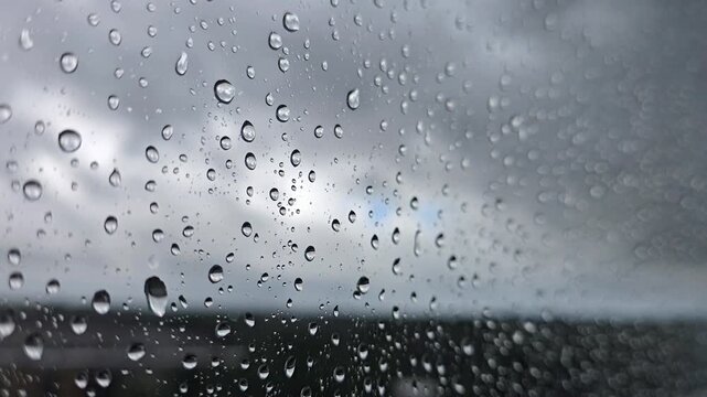 Drops of the rain sliding down slowly on window glass, rainstorm, rainy season,