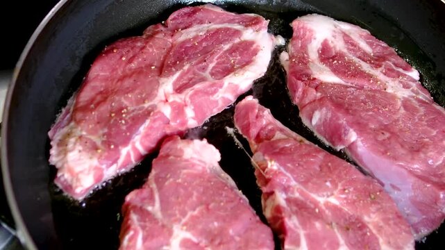 video set of a man cooking steaks in a frying pan, Chef cook sets stewpan meat steak on frying pan. Making delicious dishes process. Restaurant with gourmet cuisine. Public catering concept.