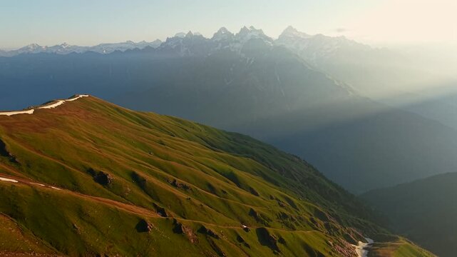 Rolling alpine ridges with distant Himalayan peaks and snow patches near Sar Pass Trek in Himachal Pradesh, India.