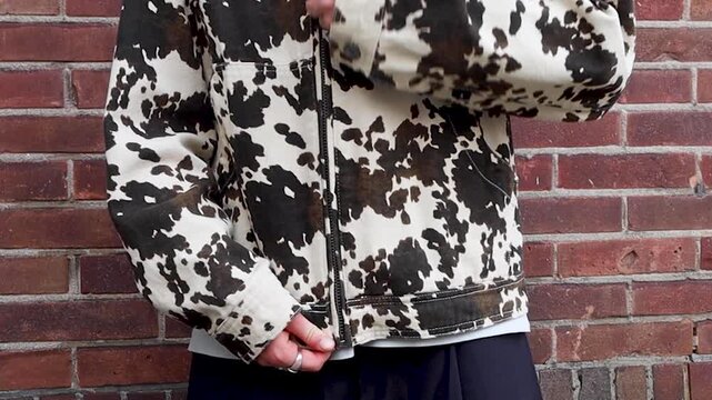 Video of a person zipping up their jacket outside.