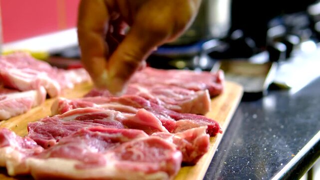 video set of a man cooking steaks in a frying pan, Chef cook sets stewpan meat steak on frying pan. Making delicious dishes process. Restaurant with gourmet cuisine. Public catering concept.