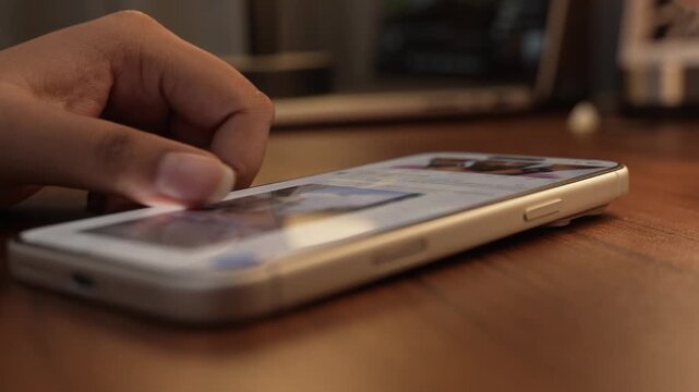Close-up of a hand scrolling through a social media feed on a smartphone, depicting digital addiction, mindless browsing, and screen dependency in daily life.