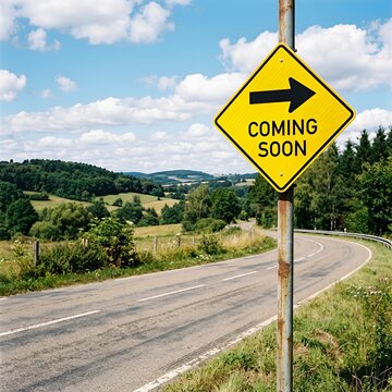 Yellow "Coming Soon" Road Sign with Arrow on Rural Landscape