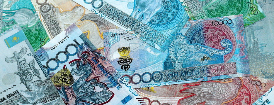 Kazakhstani tenge money banknotes pile on table. Kazakhstan bills of KZT currency close up