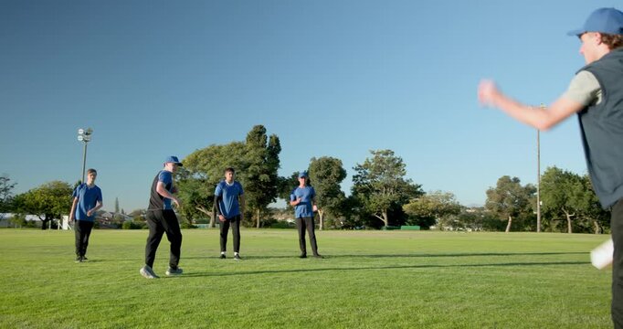 Diverse male teammates reacting to pink disc toss, lunging, catching disc in park field practice
