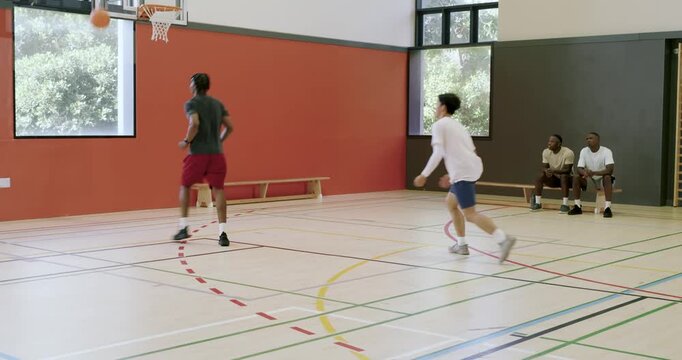 With defender closing in african american male dribbling, shooting two jumpers to score on court