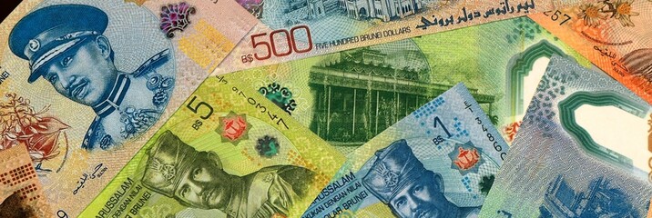 Brunei Darussalam dollar money bills in pile on table. Brunei BND currency cash close up © Viktor