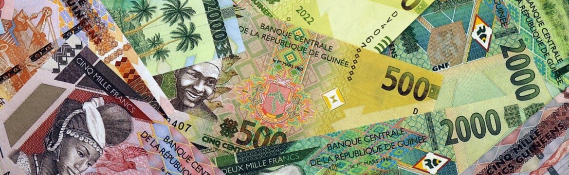 Guinean franc money bills in pile on table. Guinea GNF currency cash close up