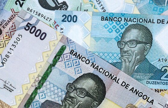 Angolan kwanza money bills in pile on table. Angola AOA currency cash close up