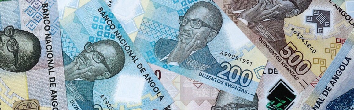 Angolan kwanza money bills in pile on table. Angola AOA currency cash close up