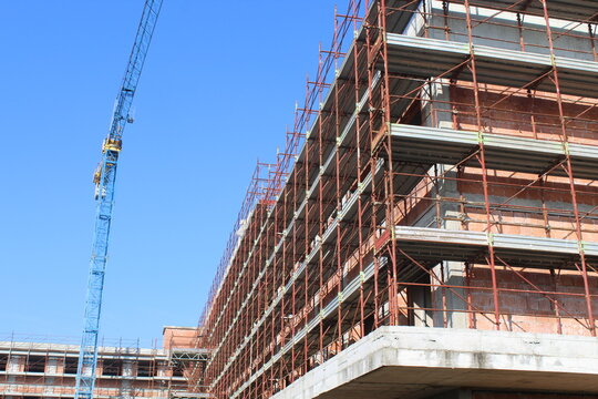 Lavori in corso nel cantiere edile in primavera - gru e ponteggio