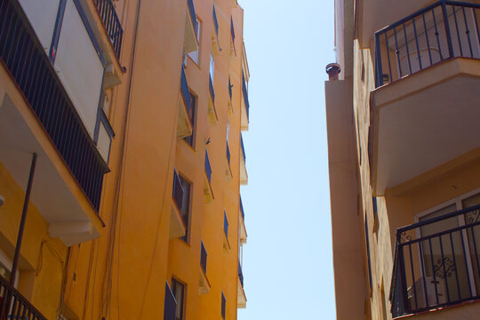 Orange Apartment Buildings Against a Blue Sky in Spain png mediterranean travel photography image photo picture hot bright sunshine spanish coast costa del sol town city modern architecture background