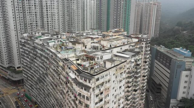 Hong Kong housing market crisis - Ascending drone shot of illegal small houses built on top of government subsidized apartment complex