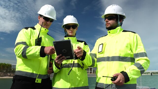Construction team collaborating on project plans urban setting industrial content daylight professional atmosphere