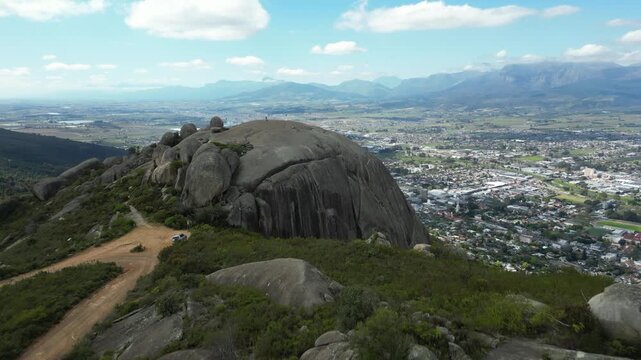 Fly over Paarl Rock granite outcrop and reveal town of Paarl below