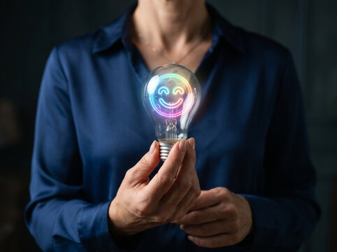 Light bulb smile customer satisfaction emotional concept person holding glowing bulb neon smile inside bulb dark background business shirt hand