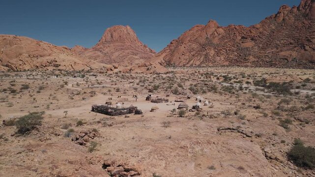 Aerial view of a traditional himba village with huts near spitzkoppe mountains in the namibian desert, africa