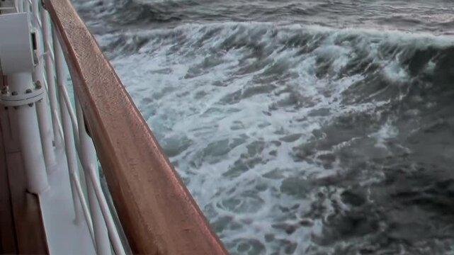 Witness the rhythmic dance of the Arctic Ocean's mighty waves from a ship's graceful passage.
