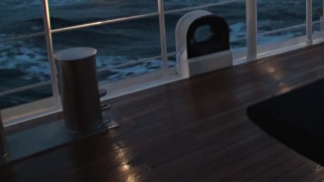 Experience the serene yet powerful journey across the Arctic Ocean. The ship's sturdy deck offers a close view of the vast, dark waves moving rhythmically during twilight.