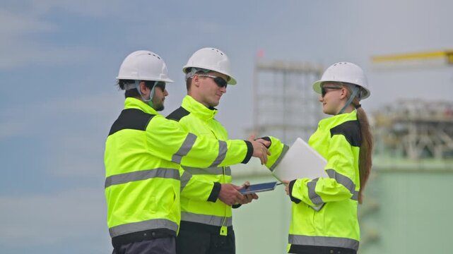 Collaboration among engineers industrial site meeting outdoor side view teamwork in action