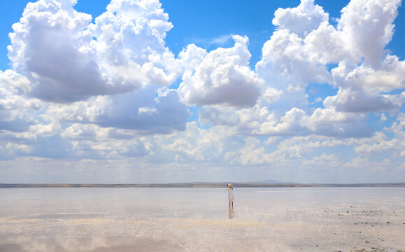 Young girl taking pictures on phone in salt lake Tuz Golu, Turkey.  Tourist takes photo using smartphone. Woman taking a picture of lake with her mobile phone.  Summer vacation, relaxing, travel, trip