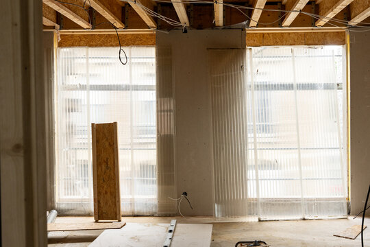 Int&eacute;rieur d&rsquo;un espace en travaux avec mat&eacute;riaux de construction, outils et surfaces inachev&eacute;es illustrant un chantier en cours de r&eacute;novation ou d&rsquo;am&eacute;nagement.