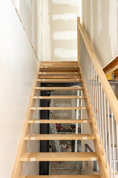 Escalier en cours de r&eacute;novation dans un int&eacute;rieur en travaux, illustrant un chantier de construction avec des mat&eacute;riaux et finitions en transformation.