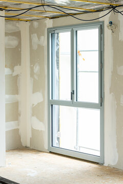 Espace en r&eacute;novation montrant des travaux sur les fen&ecirc;tres, les murs et la toiture, illustrant un chantier de transformation et de restauration d&rsquo;un b&acirc;timent.