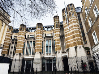 Naklejka premium Historic striped brick civic Richmond House building with tall columns and gated facade in London, UK city center