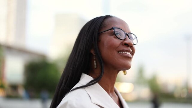 Elegant woman wearing glasses smiling in the city center

