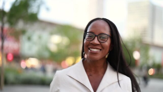 Elegant woman wearing glasses smiling in the city center

