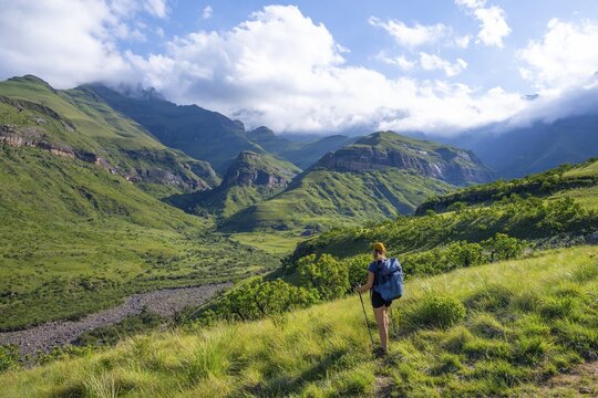 Young female hiker between mountains, Drakensberg National Park, KwaZulu Natal, South Africa