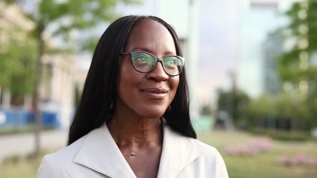 Elegant woman wearing glasses smiling in the city center
