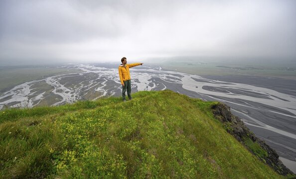Hiker on a hill, view over alluvial land, river meandering, D&iacute;monarhellir, Su&eth;urland, Iceland